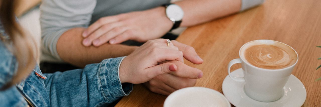 How to Treat Someone With Schizophrenia or Psychosis close up photo of two people holding hands while having coffee
