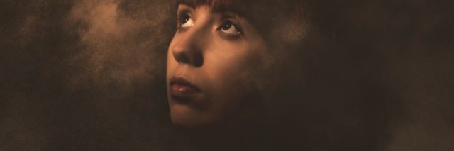 photo of woman with questioning expression looking up and surrounded by smoke