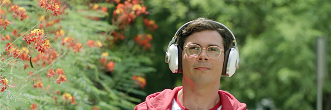 Ryan, the main character in "Special" wearing headphones outside.
