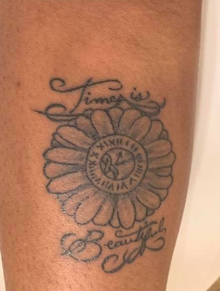 woman's tattoo with a clock shaped like a flower. it says 'time is beautiful'