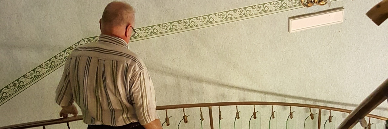 What It's Like Traveling With My Husband Who Has Dementia man walking down spiral staircase