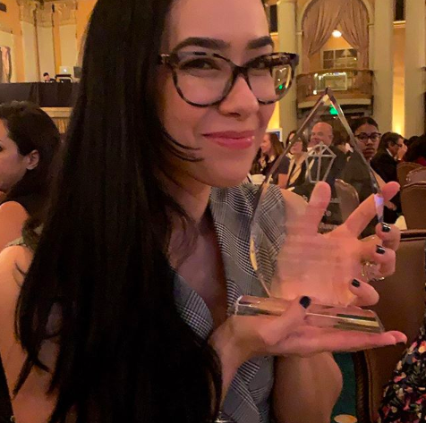 Image of AJ Mendez Brooks holding an award