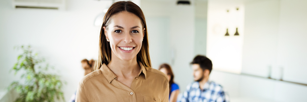 A Guide for Working With Lupus A woman standing in her office, holding an ipad