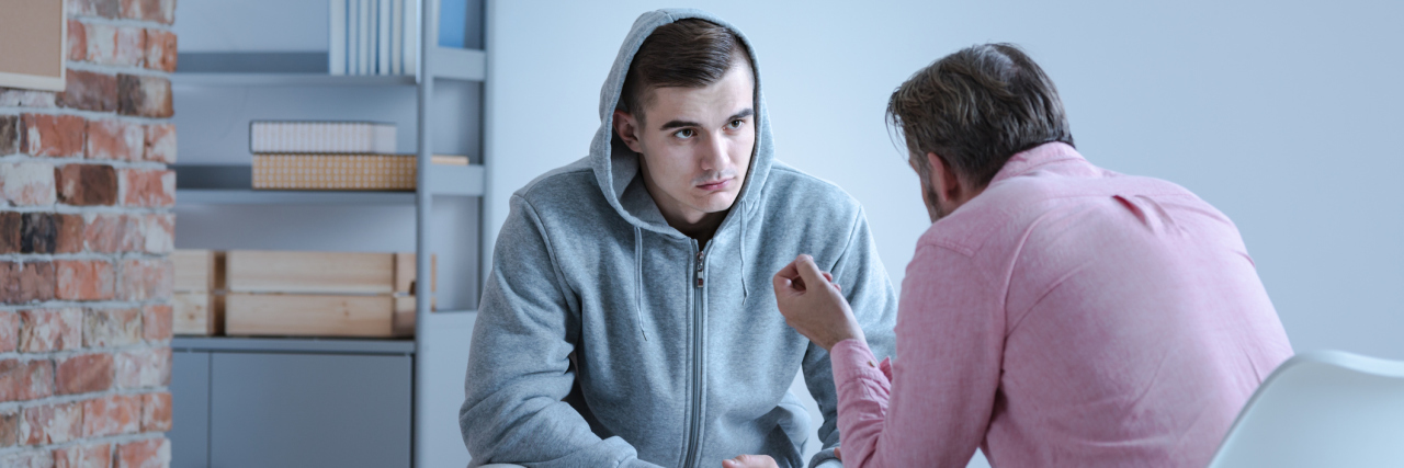 Gestalt Therapy Can Teach You About Your Body and Mind A psychology specialist explaining an action plan for recovery to a troubled teenage boy during an individual therapy session.