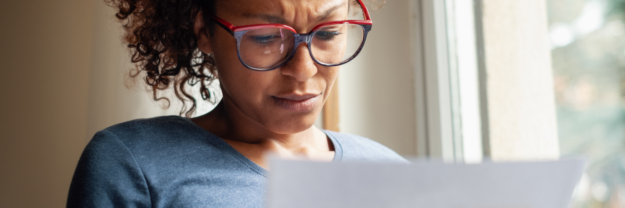 Experiencing Job Discrimination Based on a Disability Woman looking at a piece of paper unhappy about what she is reading.
