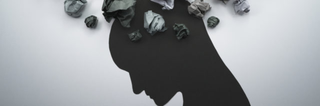 Waste paper forms thought clouds above a human silhouette with a bowed head.