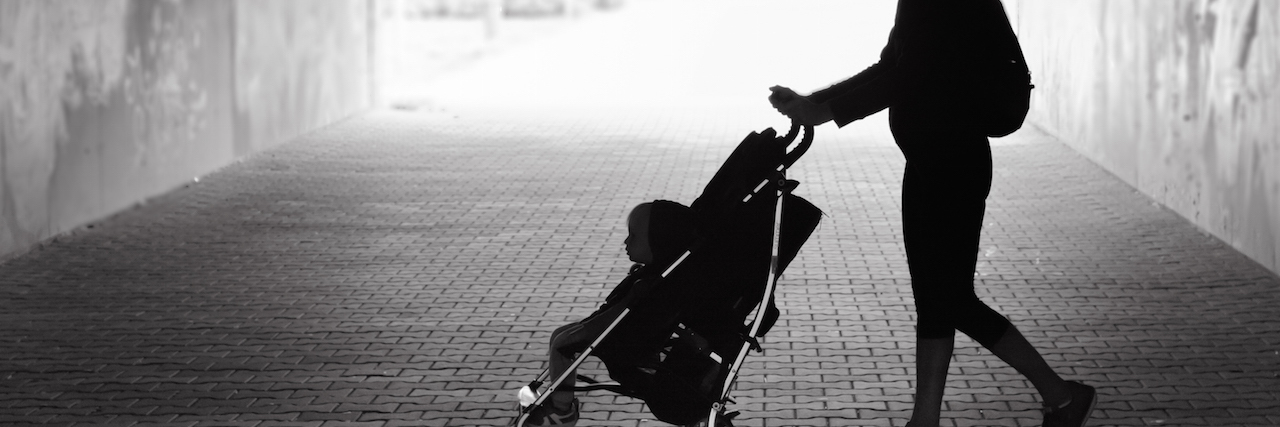 A woman walking her baby in a stroller