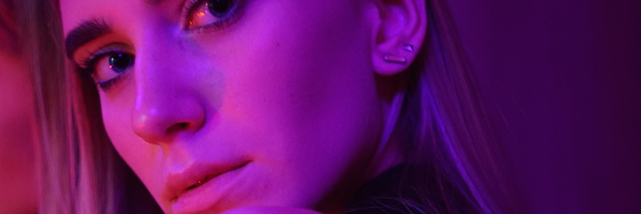 Borderline Personality Disorder and Attention-Seeking Behavior A woman looking over her shoulder in red lighting