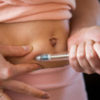 a woman is making on a hormone injection on her stomach