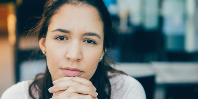 How Developing Multiple Sclerosis Saved My Life A woman looking ahead with her hands clasped