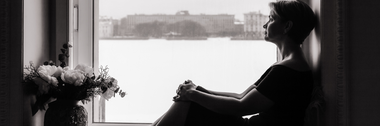 The 6 Most Important Things My Therapist Told Me a woman is sitting on a windowsill and looking at the street.