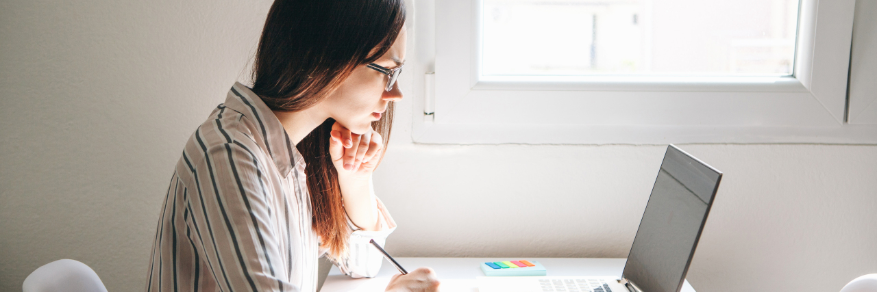 Why I'm So Open About My Borderline Personality Disorder a woman sitting at a desk working on a laptop