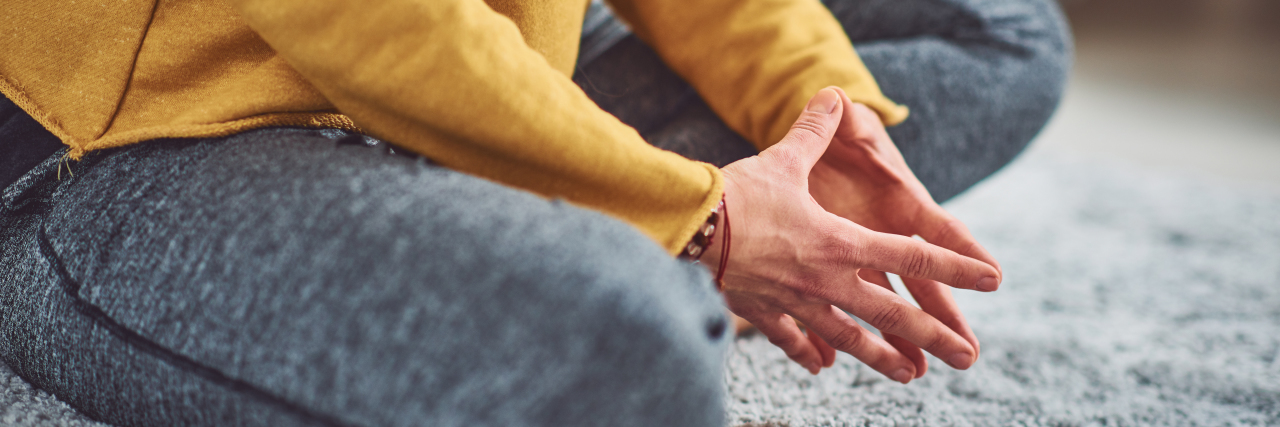 How to Know If You've Found a Good Therapist close up photo of woman sitting cross legged on floor in lotus pose with hands together