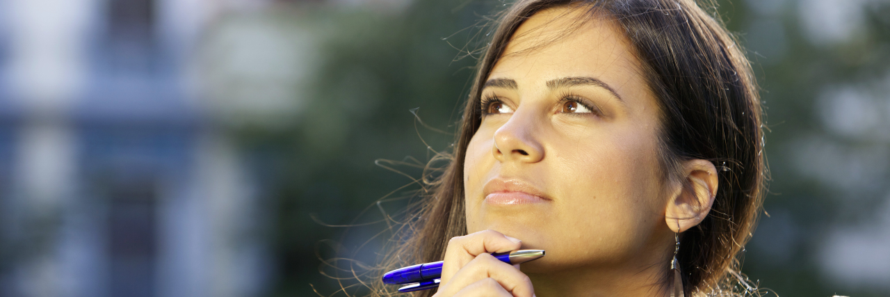 Multiple Sclerosis Is Just Part of My Life Young woman with a pen in her hand thinking.