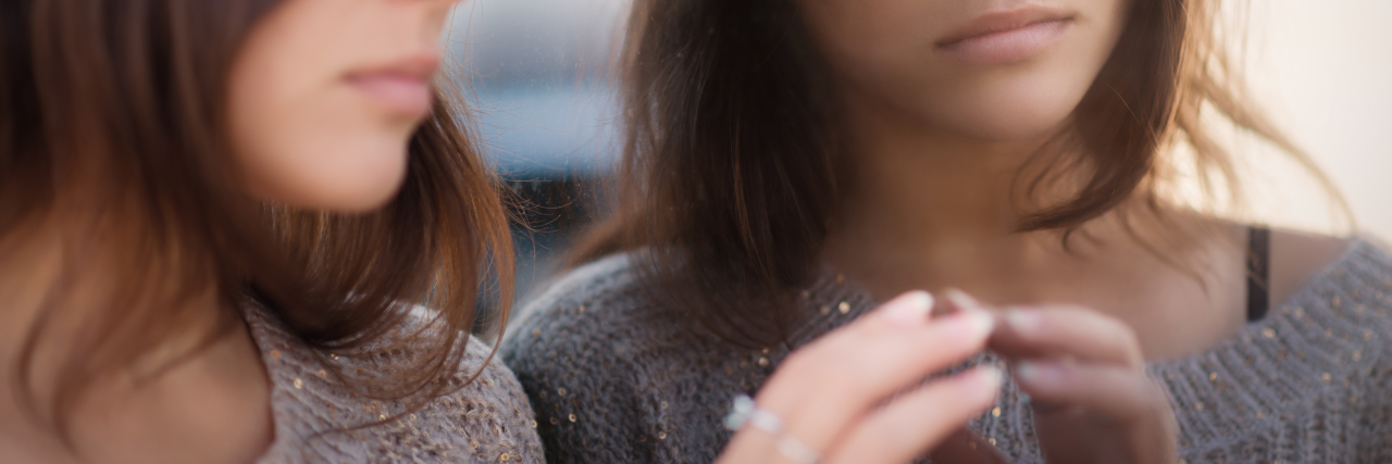 Answering the Question, 'Was Your Eating Disorder Bad?' a brunette woman is looking in the mirror