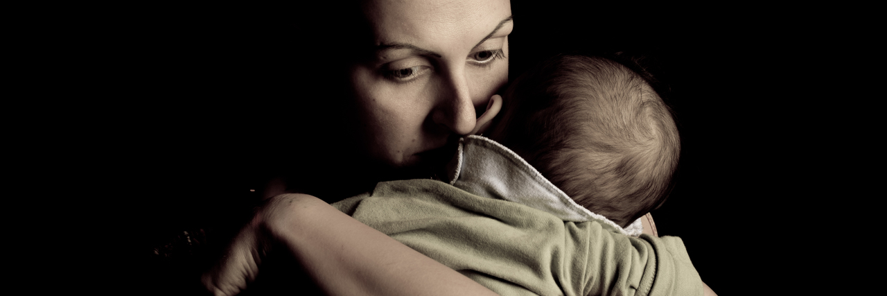 Experiencing Grief When Your Child Is Medically Complex mother holding a child, looking down