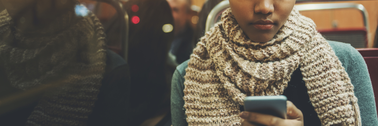 Helpful Texts to Send Someone With a Chronic or Mental Illness woman reading text message on phone while sitting on bus or train