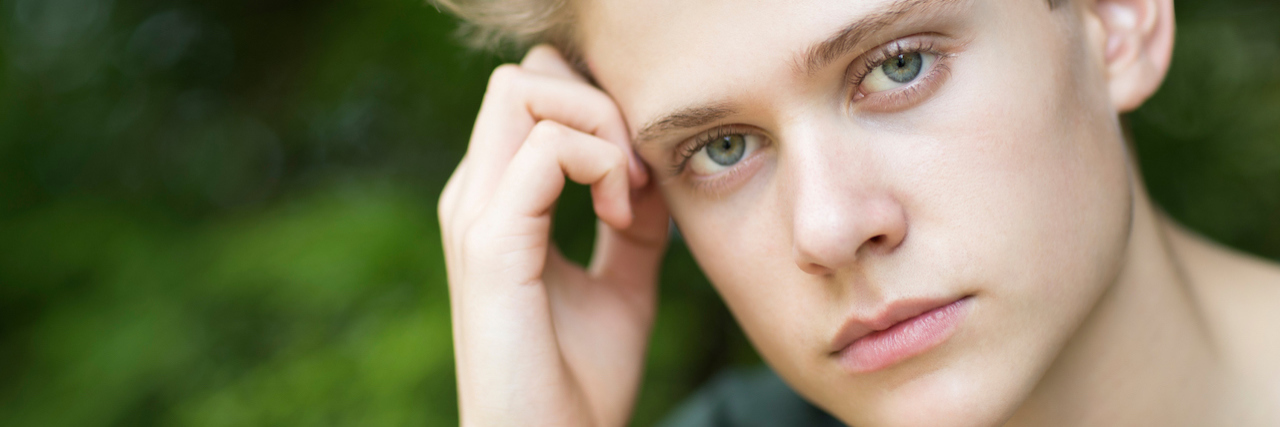 My Son Hid His Depression From Me Before He Died by Suicide A young man looking straight ahead, looking unhappy