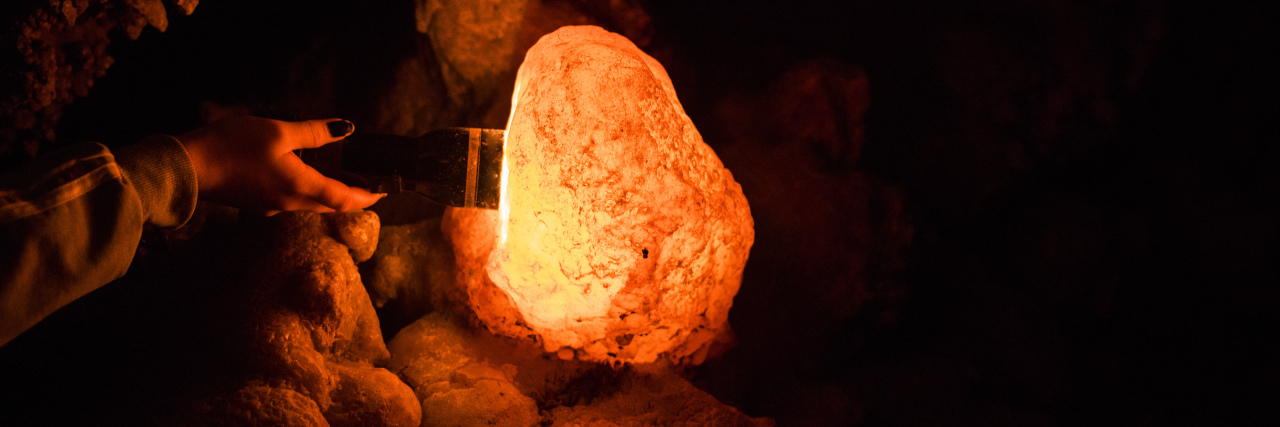 When Depression Feels Like a Hole abstract photo of a cave and a flashlight