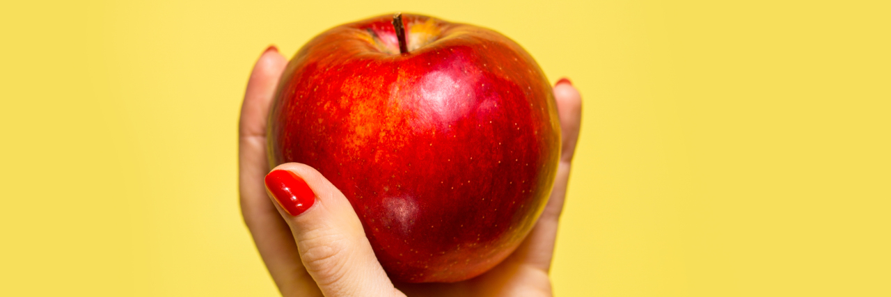 Mast Cell Activation Syndrome: What Doctors Should Know An apple in a hand over yellow background