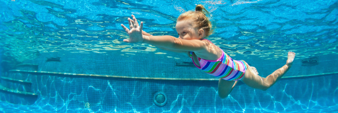 A young girl swimming in a pool, underwater shot