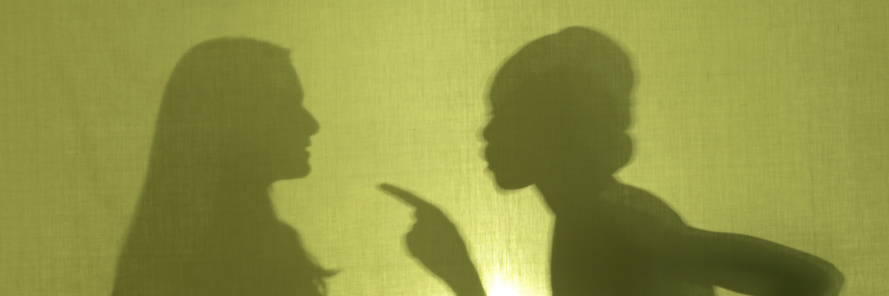 Silhouette of woman scolding another woman.