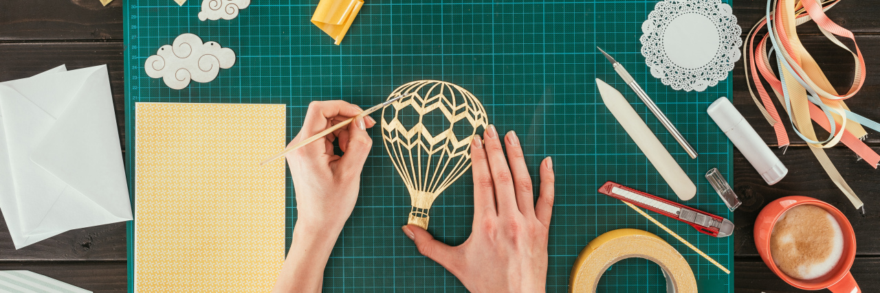 Fibromyalgia Friendly Activities Woman crafting doing paper cutouts.