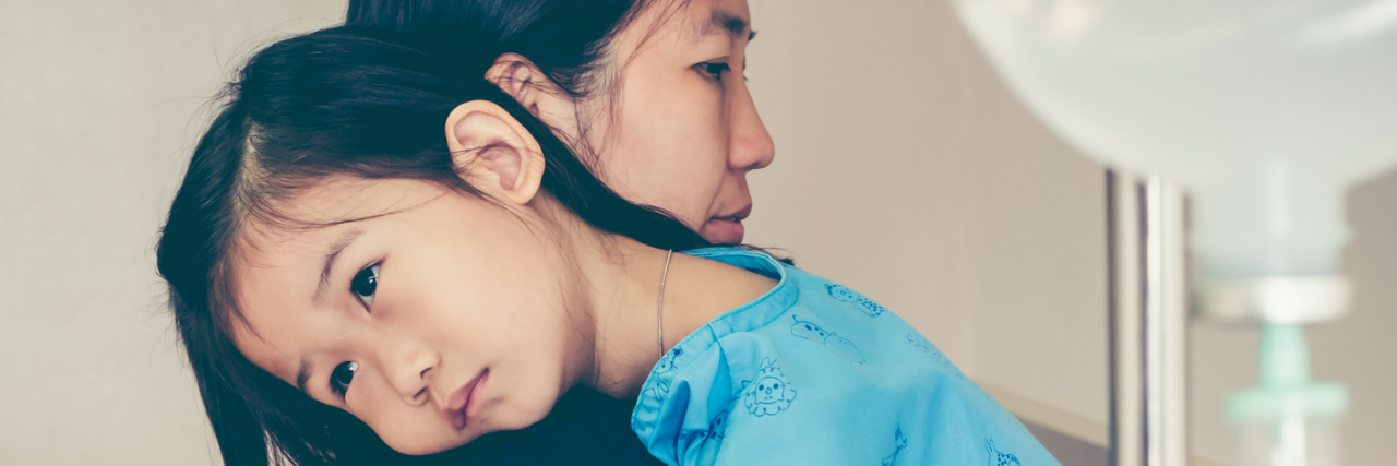 'Survival Mode' When You Parent a Chronically Ill Child Mother carrying sick child at hospital.