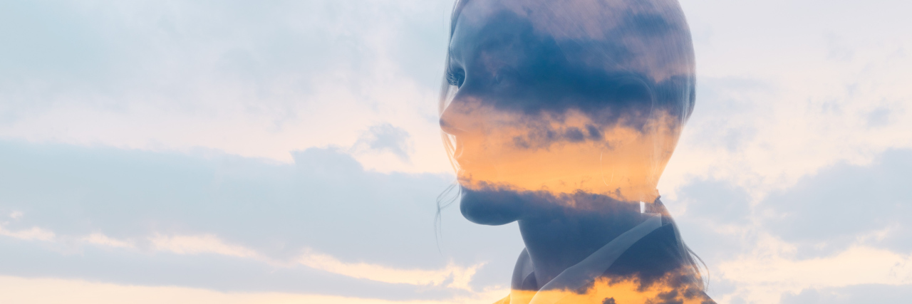 Double exposure of woman face and sunset glow.