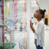 Young black girl looking at a science exhibit.