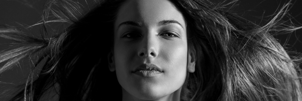 Moving Beyond Imposter Syndrome With Chronic Illness Black and white portrait of woman with flowing hair.