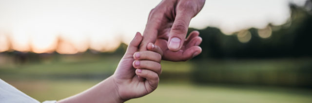 Dad holding son's hand