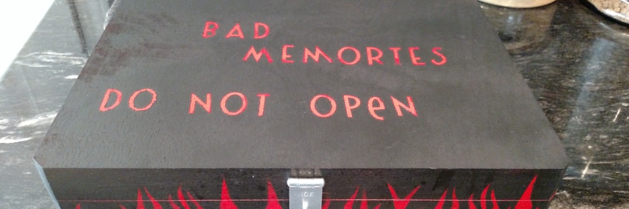 How 'Containment' Can Help With Trauma Memories photo of black painted box with silver lock and painted red flames. On the top is written "bad memories, do not open"