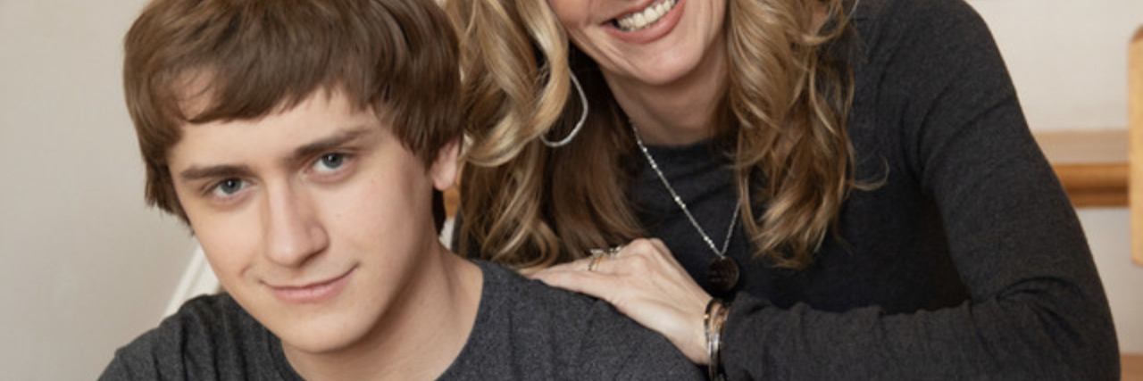 Words of Wisdom From a Mom of an Autistic Teen Kathy and Ryan Hooven sitting on stairs and smiling at camera.