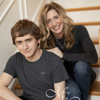 Kathy and Ryan Hooven sitting on stairs and smiling at camera.