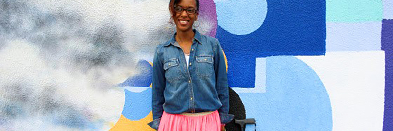 Cerebral Palsy Is My Superpower Kim, African-American young woman standing with a cane.
