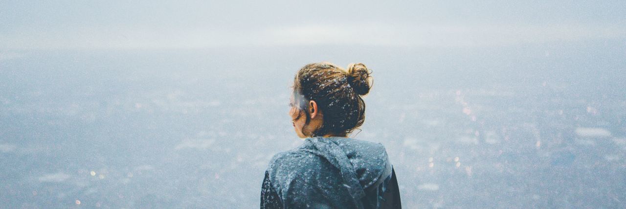 How to Cope When PTSD Makes You Terrified and Angry photo of young blonde woman looking out over city from high up