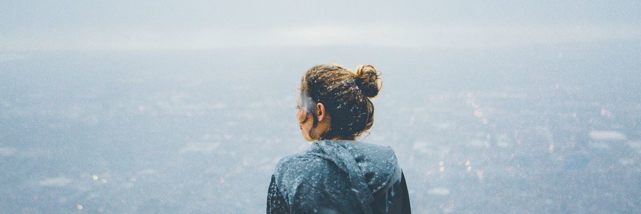photo of young blonde woman looking out over city from high up