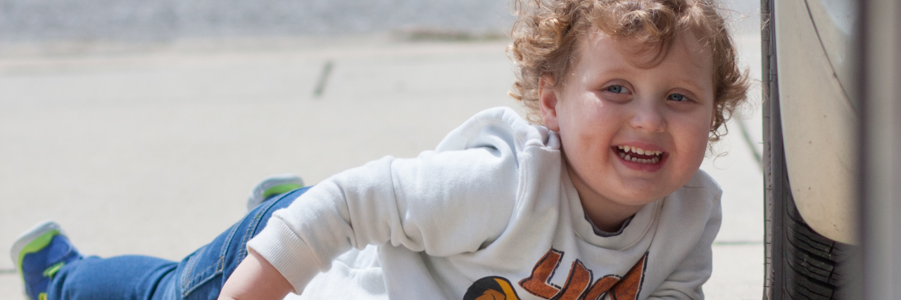 Autism: How My Son Is Changing the Conversation Noah laying on driveway smiling at camera