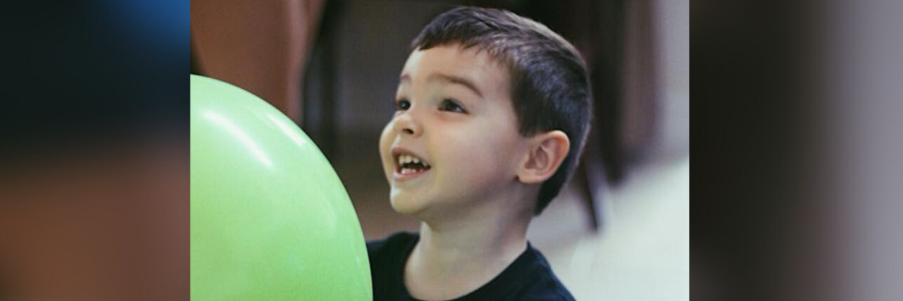 Planning a Birthday Party for a Child With Autism Barclay enjoying a green balloon on his birthday.