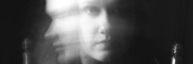 black and white double exposure photo of woman turning head quickly