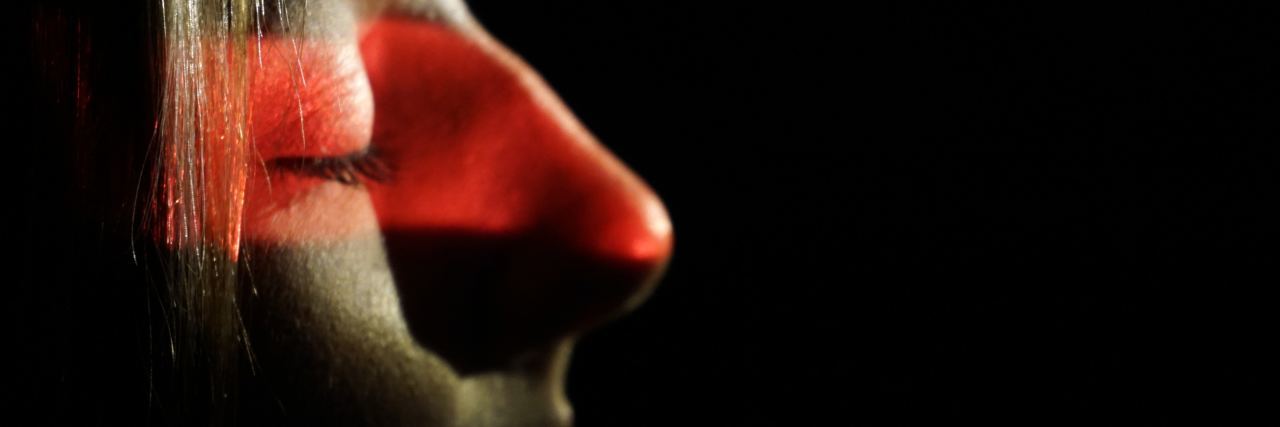 Ways to Live With PTSD Flashbacks close up of young woman with closed eyes and red band of light across eyes