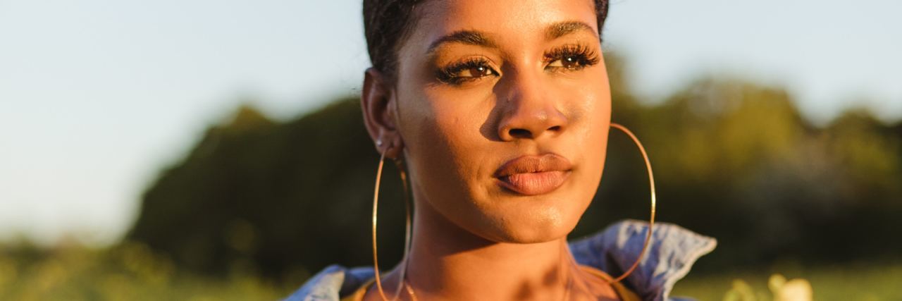 I Don't Want Children Because of Childhood Trauma photo of woman standing in field of long yellow flowers at sunset looking into distance
