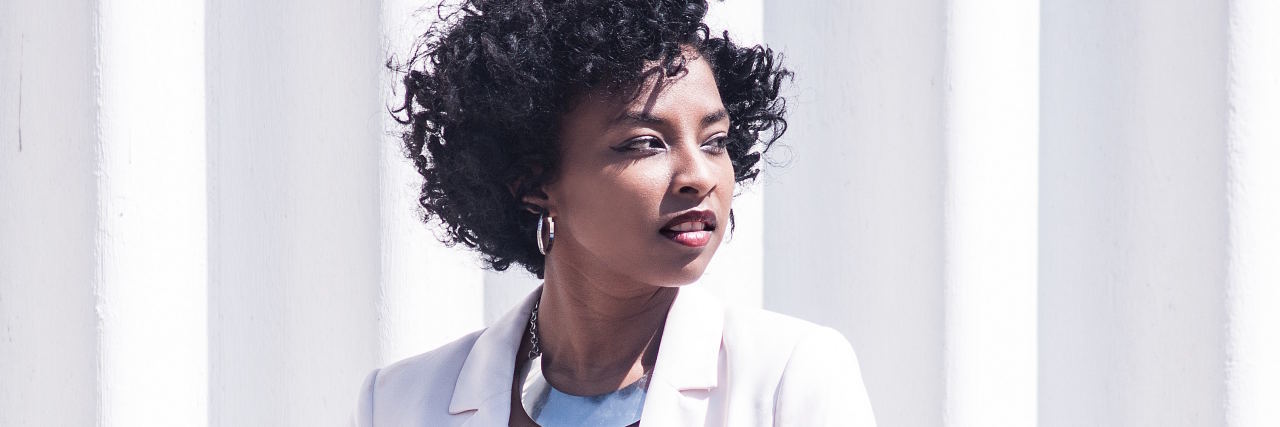 What Social Anxiety Feels Like Physically woman in white blazer looking to the right