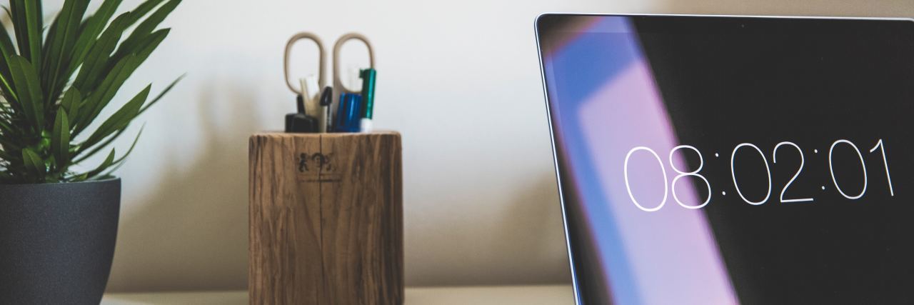 7 Companies With Work-From-Home Jobs Available This June Plant, cup holding office supplies and open laptop computer on white desk