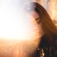 photo of woman in bright light flare with eyes closed