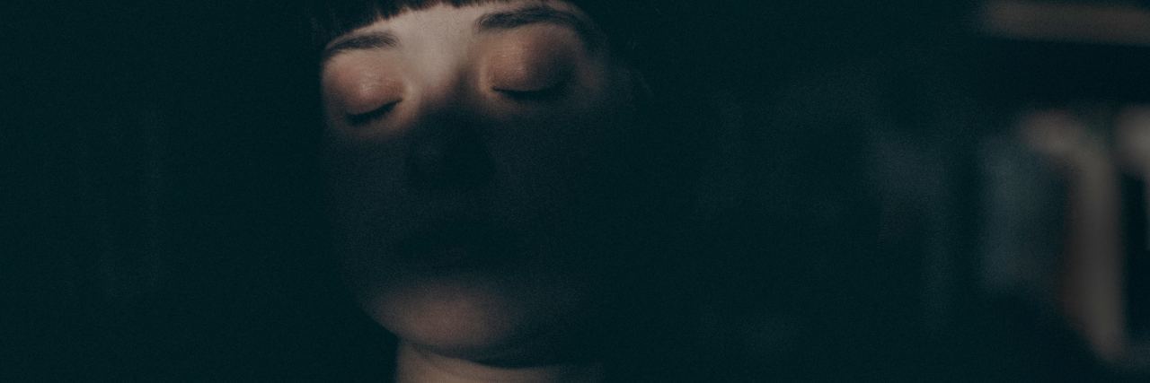 When You Feel Like a 'Bother' by Talking About Mental Illness photo of woman cast in darkness with closed eyes