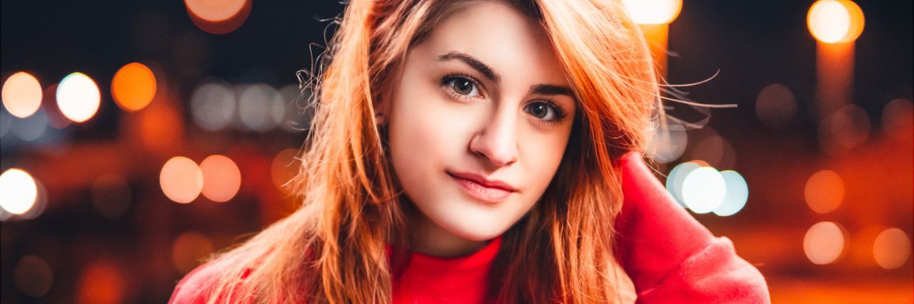 My Psychiatrist Thinks I'm OK Because I Smiled photo of woman with red hair smiling slightly for camera