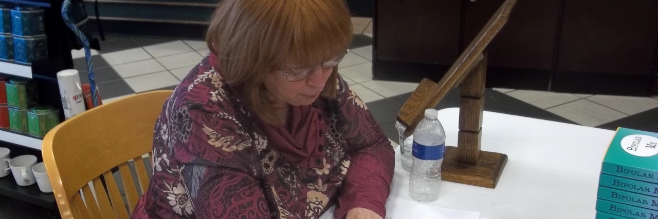 Why You Should Ignore Anxiety and Do What You're Afraid Of writer janet coburn signing her book in bookstore