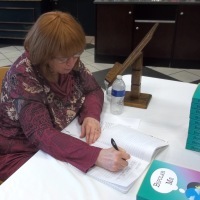 writer janet coburn signing her book in bookstore